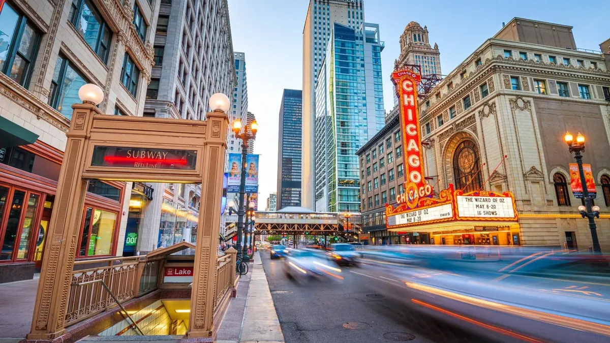 The Chicago Theatre marquee on State Street in the Loop with traffic passing at dusk